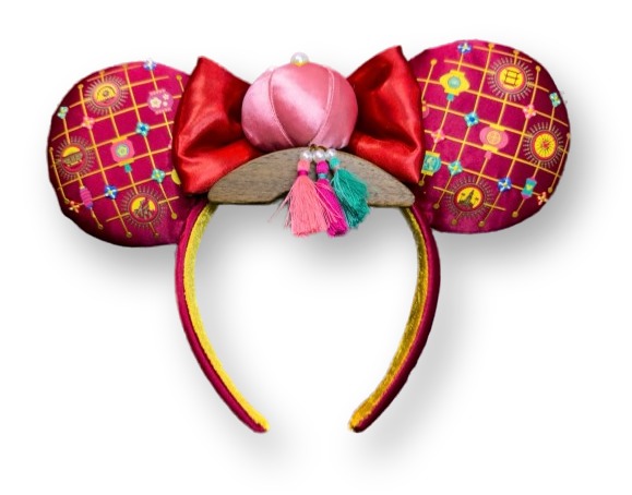 Deep red ear headband with gold lantern print, a red bow, and a pink tasseled lantern charm for Lunar New Year 2026
