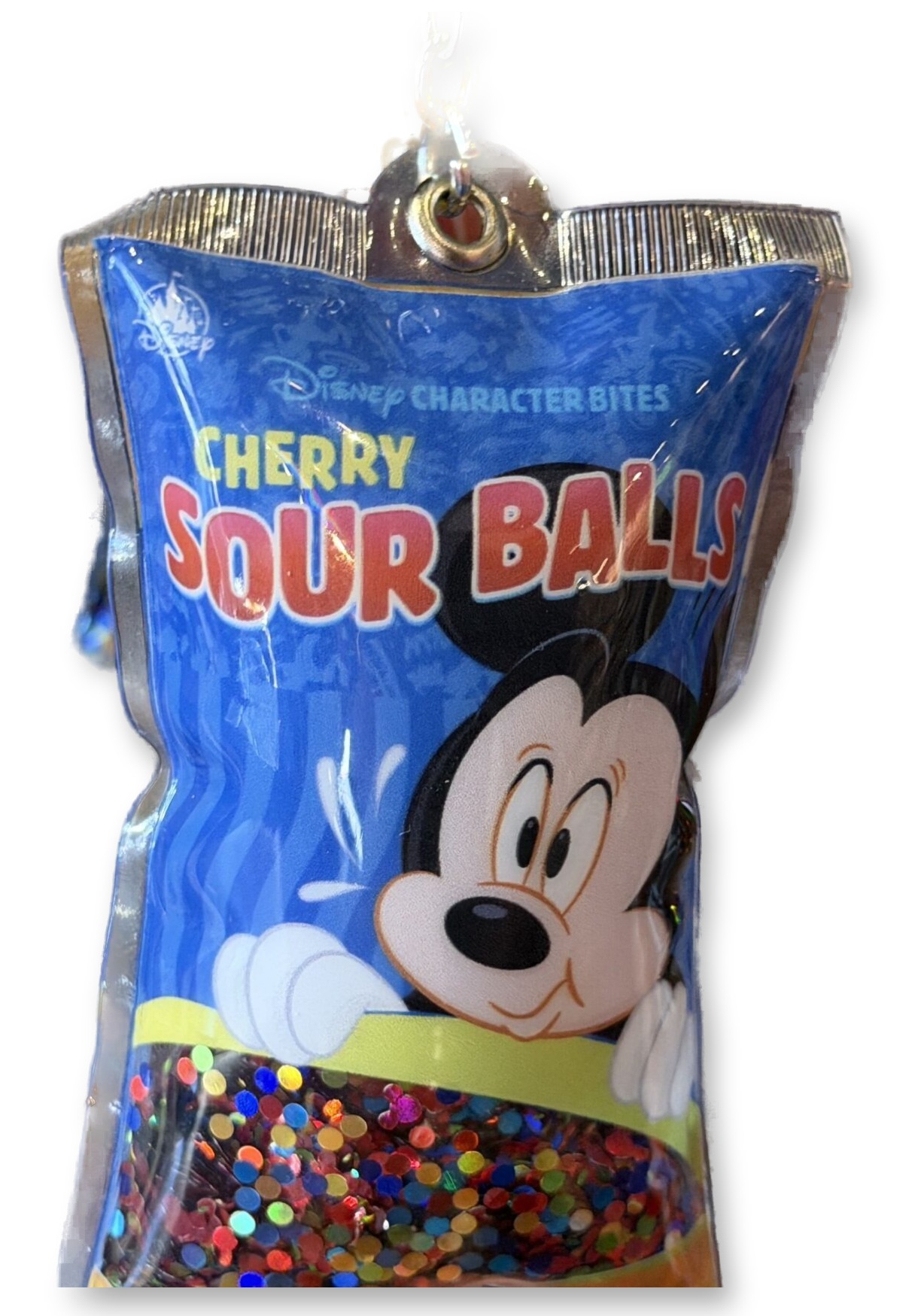 Hand holding a 'Cherry Sour Balls' miniature candy bag keychain featuring Mickey Mouse, filled with rainbow confetti, with its price tag attached