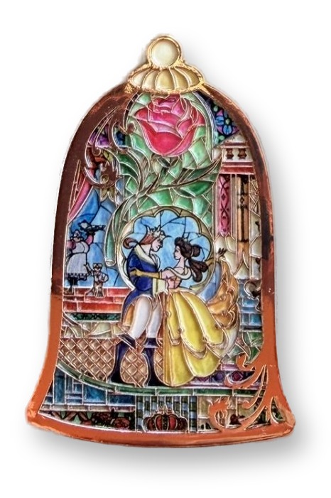 A gold-toned enamel pin shaped like an arched stained-glass window, showing Belle in a yellow gown dancing with the Prince beneath a large pink rose, mounted on a Beauty and the Beast D23 2026 Shoe Palace backing card.