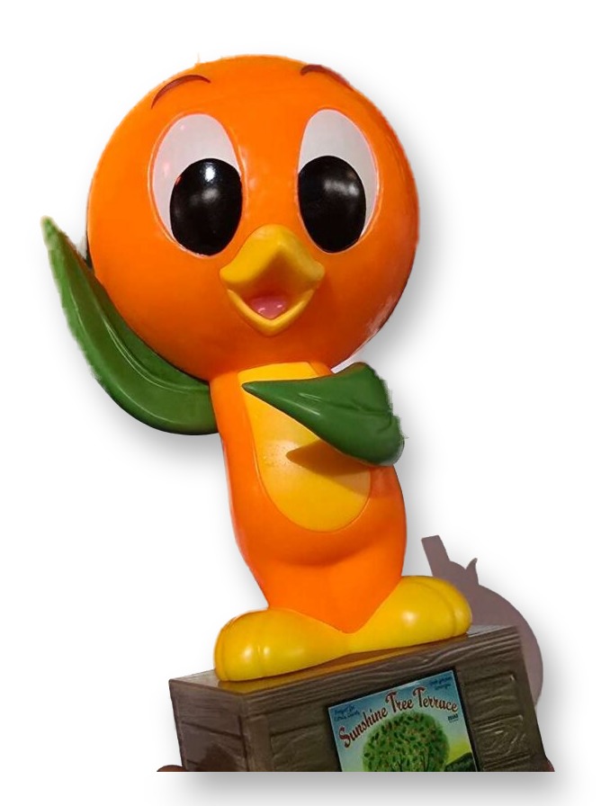Orange Bird sipper cup, a round orange bird figure with a yellow beak and green leaf wings, standing on a wooden crate printed with the Sunshine Tree Terrace logo, photographed against a leafy backdrop mural.
