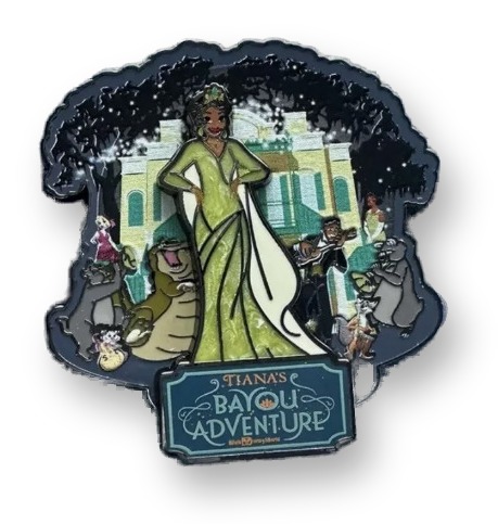 Enamel pin depicting Princess Tiana in a green gown with Louis, Naveen, Lottie, and Eudora in front of a mansion, with a hanging Tiana's Bayou Adventure logo charm below.