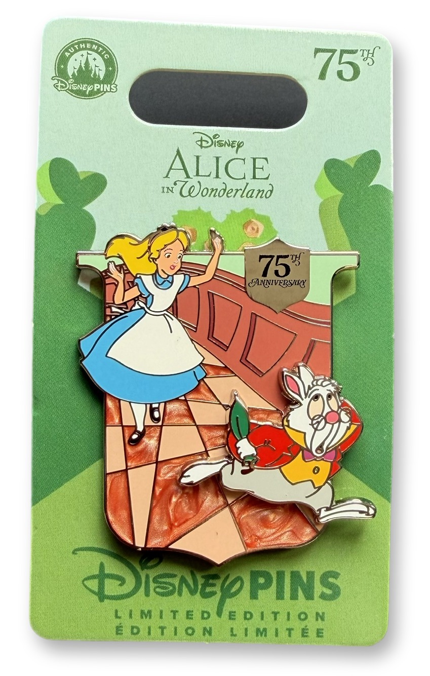Enamel pin on its Pins backing card showing Alice reaching out as the White Rabbit runs past on a tiled garden path with a silver 75th Anniversary shield charm