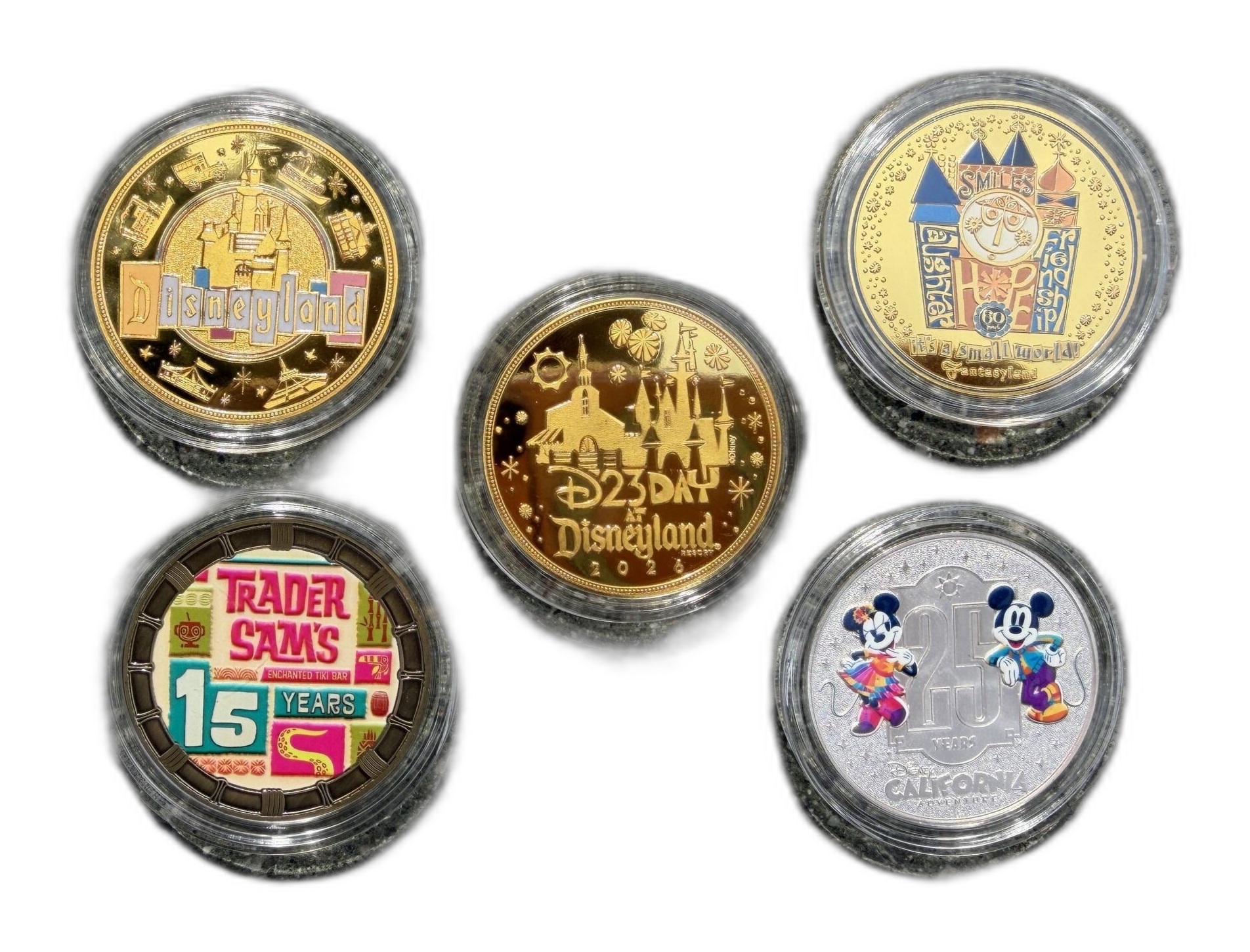 Four D23 Day at Disneyland 2026 commemorative medallion designs with a reverse view